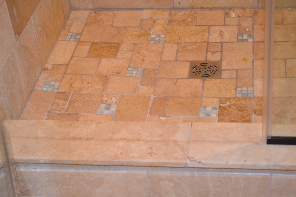 Esempio di una stanza da bagno padronale stile americano di medie dimensioni con piastrelle in pietra, doccia ad angolo, piastrelle beige e pareti beige