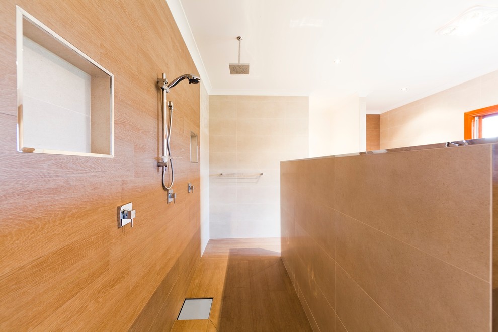Inspiration pour une salle de bain design avec une baignoire indépendante, une douche ouverte, un carrelage beige, des carreaux de porcelaine, un mur beige et un sol en carrelage de porcelaine.