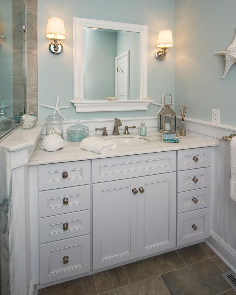 Ejemplo de cuarto de baño marinero con lavabo bajoencimera, armarios con paneles empotrados, puertas de armario blancas y baldosas y/o azulejos beige
