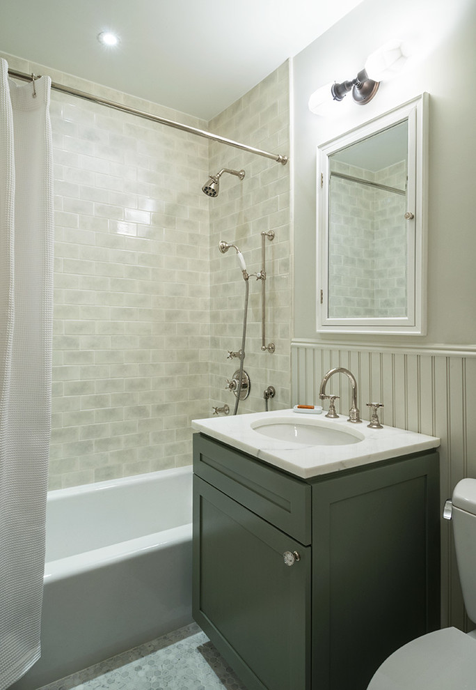 Inredning av ett klassiskt badrum, med ett undermonterad handfat, skåp i shakerstil, grå skåp, ett badkar i en alkov, en dusch/badkar-kombination, en toalettstol med separat cisternkåpa, grå kakel, tunnelbanekakel, vita väggar och mosaikgolv