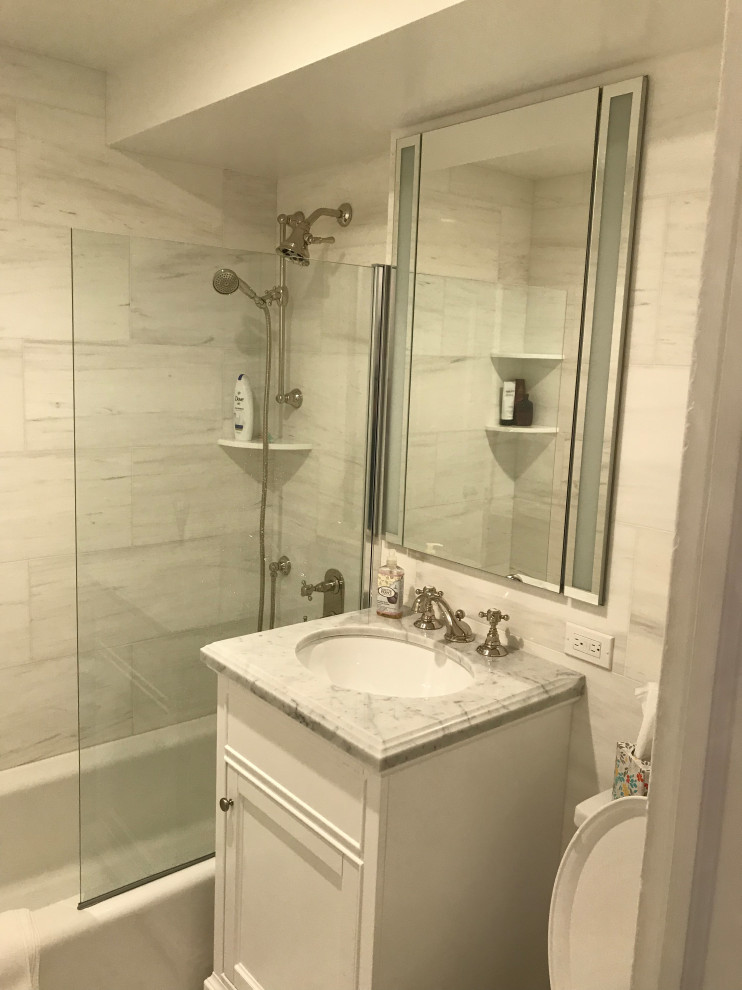 ニューヨークにある高級な小さなトランジショナルスタイルのおしゃれなバスルーム (浴槽なし) (インセット扉のキャビネット、白いキャビネット、アルコーブ型浴槽、シャワー付き浴槽	、分離型トイレ、白いタイル、磁器タイル、白い壁、モザイクタイル、アンダーカウンター洗面器、クオーツストーンの洗面台、白い床、開き戸のシャワー、白い洗面カウンター) の写真