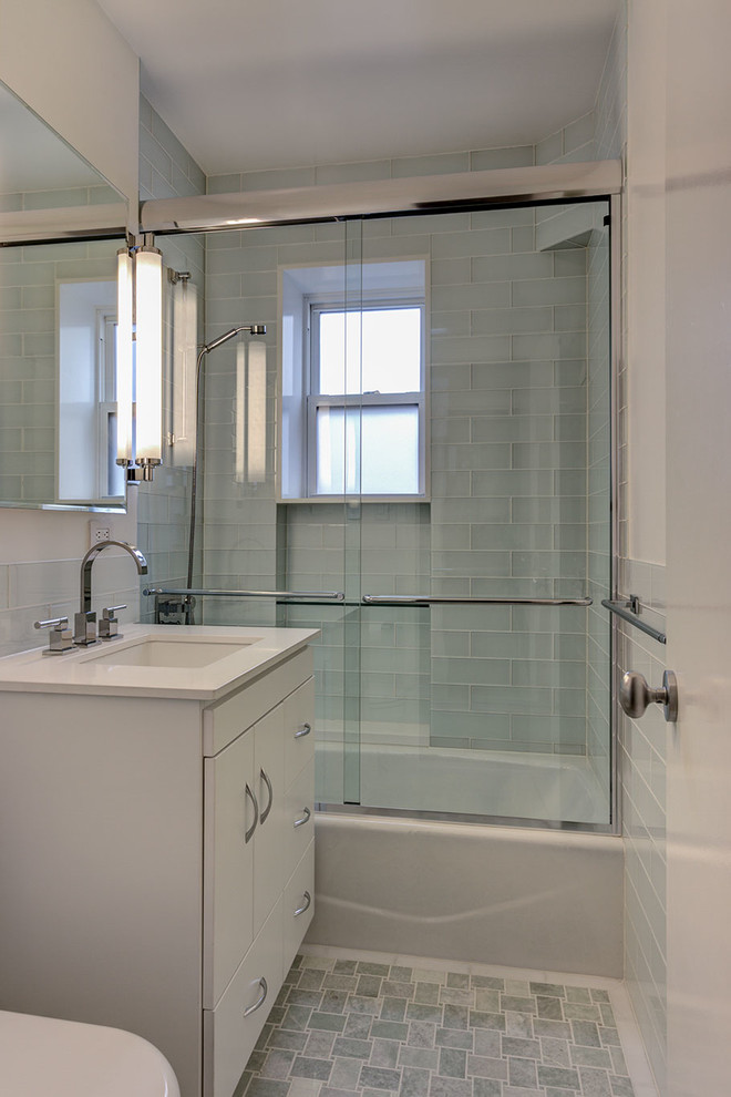 Foto di una stanza da bagno classica con lavabo sottopiano, ante lisce, ante bianche, top in quarzo composito, vasca ad alcova, vasca/doccia, piastrelle grigie e piastrelle di vetro