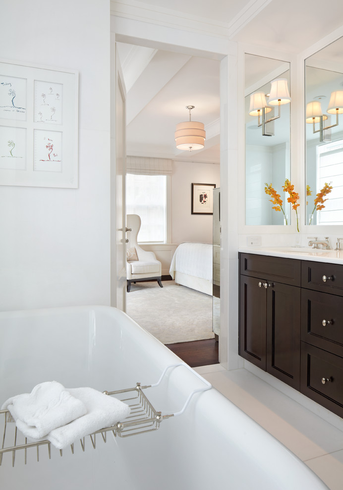 Design ideas for a medium sized classic ensuite bathroom in New York with recessed-panel cabinets, dark wood cabinets, white walls, a submerged sink, a freestanding bath, a corner shower, a one-piece toilet and marble flooring.