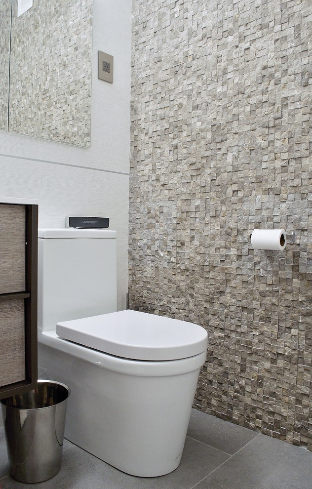 Idéer för att renovera ett litet funkis toalett, med ett integrerad handfat, släta luckor, skåp i ljust trä, en toalettstol med hel cisternkåpa, grå kakel, stenkakel, bruna väggar och klinkergolv i porslin