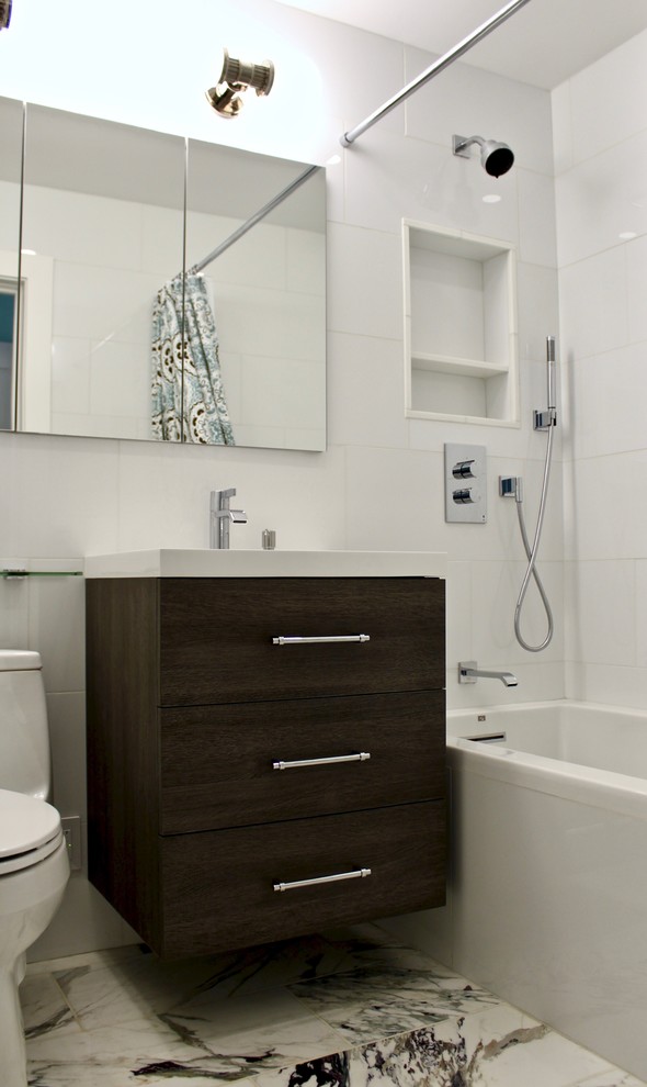 Idéer för ett litet klassiskt badrum för barn, med möbel-liknande, skåp i mellenmörkt trä, ett badkar i en alkov, en dusch/badkar-kombination, en toalettstol med hel cisternkåpa, vit kakel, porslinskakel, ett väggmonterat handfat, bänkskiva i kalksten, dusch med duschdraperi, vita väggar, marmorgolv och vitt golv