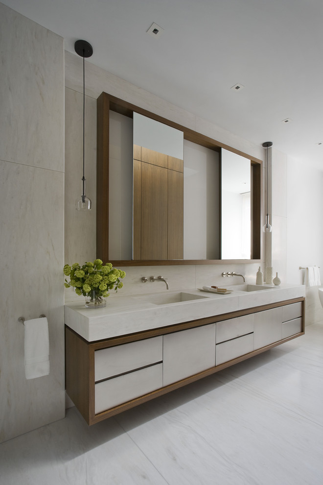 Photo of a contemporary bathroom in New York with an integrated sink, flat-panel cabinets and beige tiles.