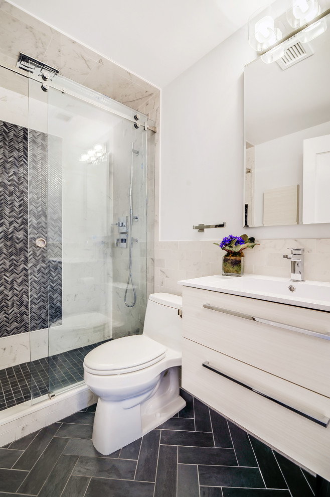 Inspiration for a mid-sized transitional master gray tile and ceramic tile ceramic tile alcove shower remodel in New York with flat-panel cabinets, white cabinets, a one-piece toilet, a console sink, solid surface countertops and white walls