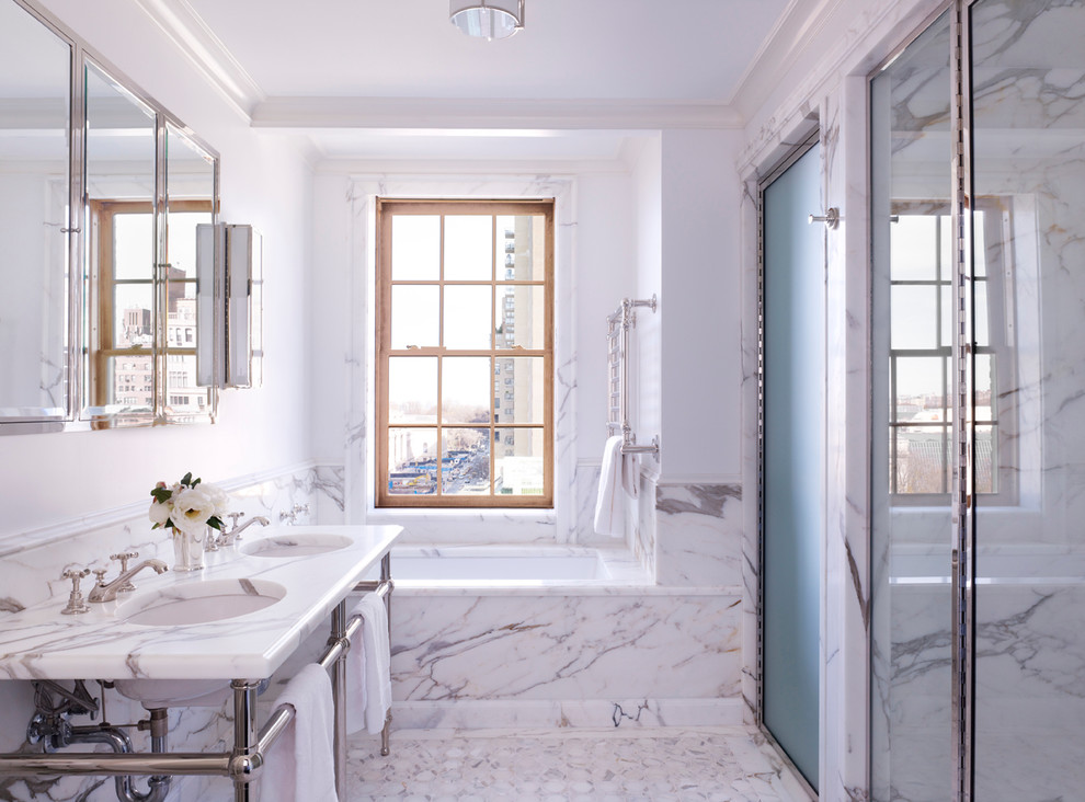 This is an example of a traditional bathroom in New York with a submerged sink, marble worktops, an alcove bath, an alcove shower, white tiles and stone slabs.