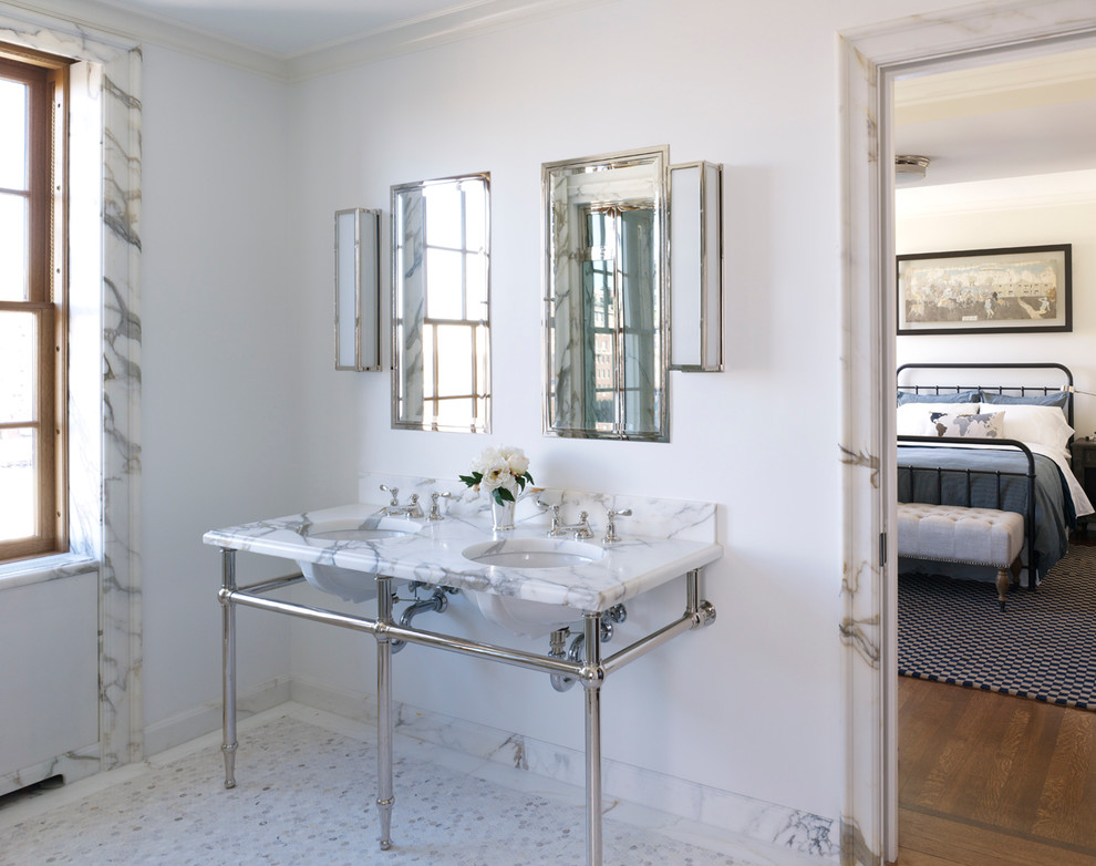 Cette photo montre une salle de bain chic avec un lavabo encastré, un plan de toilette en marbre, un carrelage blanc et des dalles de pierre.