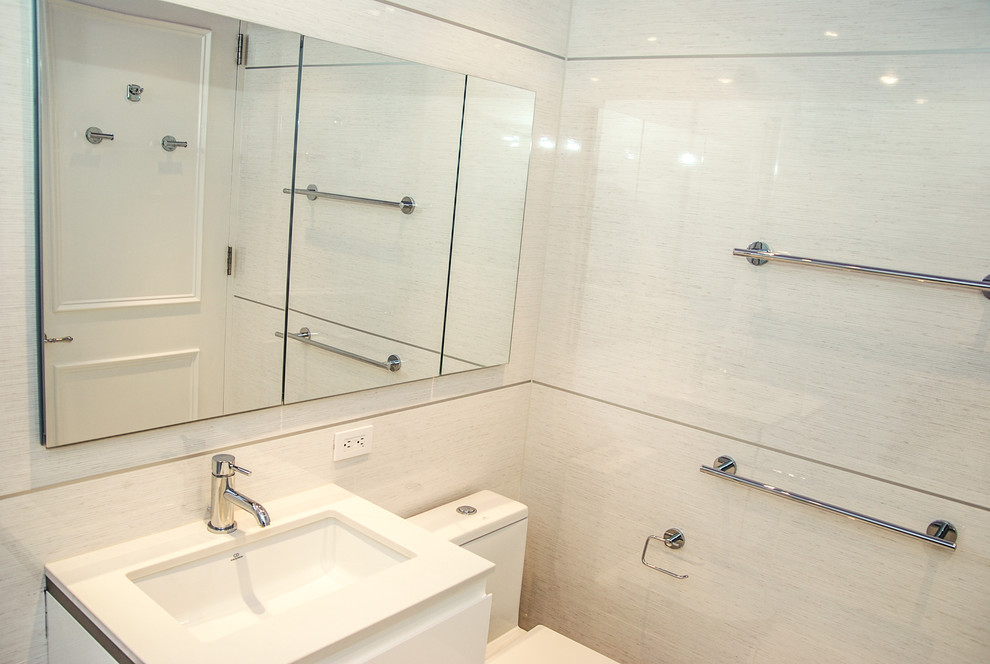 This is an example of a modern bathroom in New York with a submerged sink, white cabinets, engineered stone worktops, a built-in bath, a shower/bath combination, a one-piece toilet, white tiles and porcelain tiles.