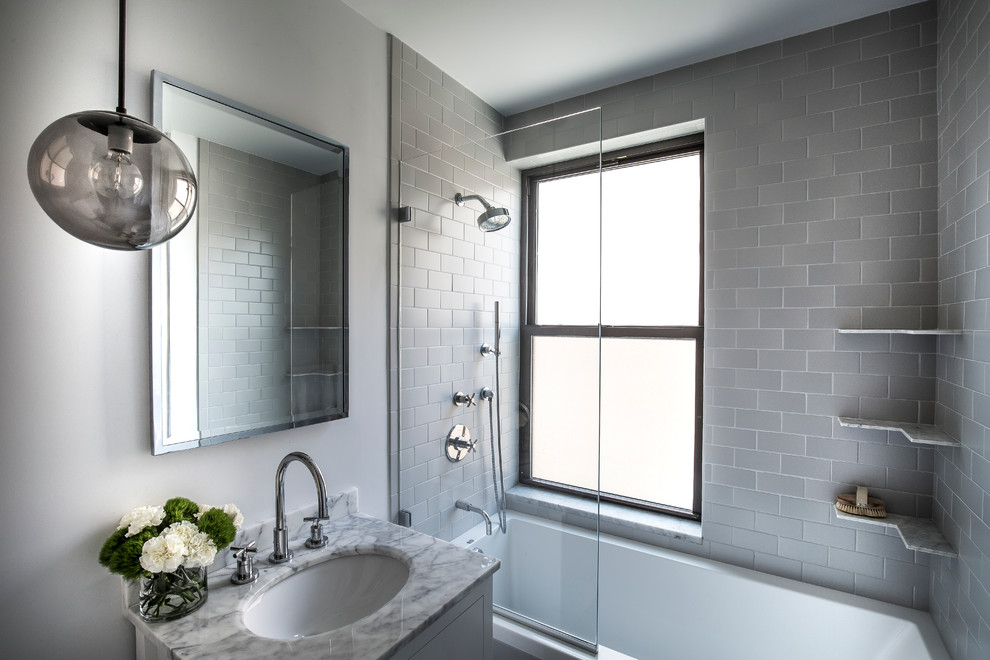 Mid-sized transitional 3/4 bathroom photo in New York with flat-panel cabinets, gray cabinets, a two-piece toilet, gray walls, an undermount sink and marble countertops