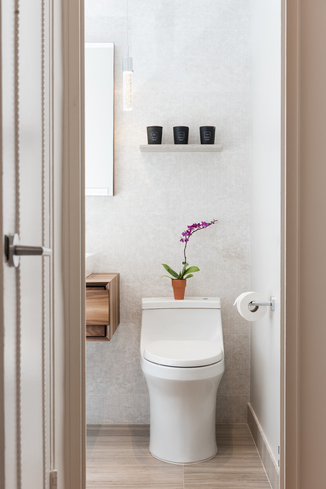 Idée de décoration pour un WC et toilettes design en bois foncé avec WC à poser, un mur gris, une vasque et un plan de toilette en bois.