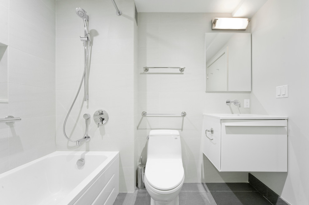 Idée de décoration pour une petite salle d'eau minimaliste avec un placard à porte plane, des portes de placard blanches, une baignoire en alcôve, un combiné douche/baignoire, WC à poser, un mur blanc, un sol en carrelage de porcelaine, un lavabo encastré, un plan de toilette en quartz, un sol gris et une cabine de douche avec un rideau.