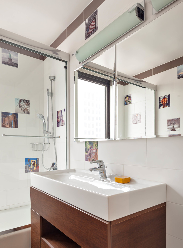 Design ideas for a contemporary shower room bathroom in New York with flat-panel cabinets, medium wood cabinets, an alcove bath, a shower/bath combination, multi-coloured tiles, white tiles, white walls, a console sink and a sliding door.