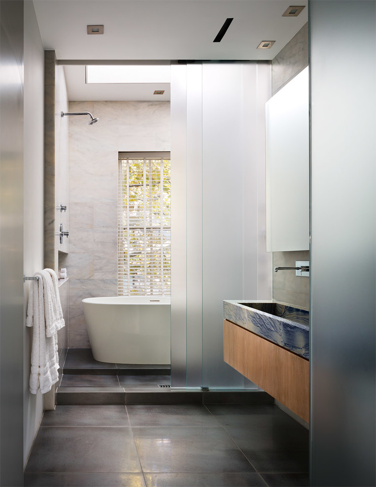 Inspiration för mellanstora klassiska en-suite badrum, med släta luckor, skåp i mellenmörkt trä, ett fristående badkar, grå kakel, ett avlångt handfat, marmorbänkskiva, en öppen dusch, stenkakel, vita väggar, klinkergolv i porslin och med dusch som är öppen