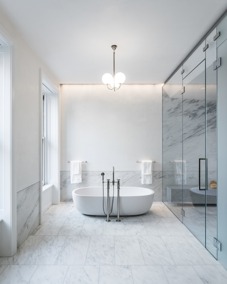 Immagine di un'ampia stanza da bagno padronale moderna con vasca freestanding, doccia doppia, lastra di pietra, pareti bianche, top in marmo, porta doccia a battente e top bianco