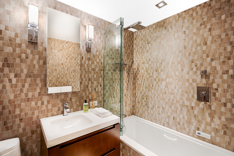 Exempel på ett mellanstort modernt vit vitt en-suite badrum, med möbel-liknande, skåp i mörkt trä, ett platsbyggt badkar, en dusch/badkar-kombination, en vägghängd toalettstol, brun kakel, keramikplattor, gula väggar, klinkergolv i keramik, ett nedsänkt handfat, marmorbänkskiva, beiget golv och dusch med skjutdörr