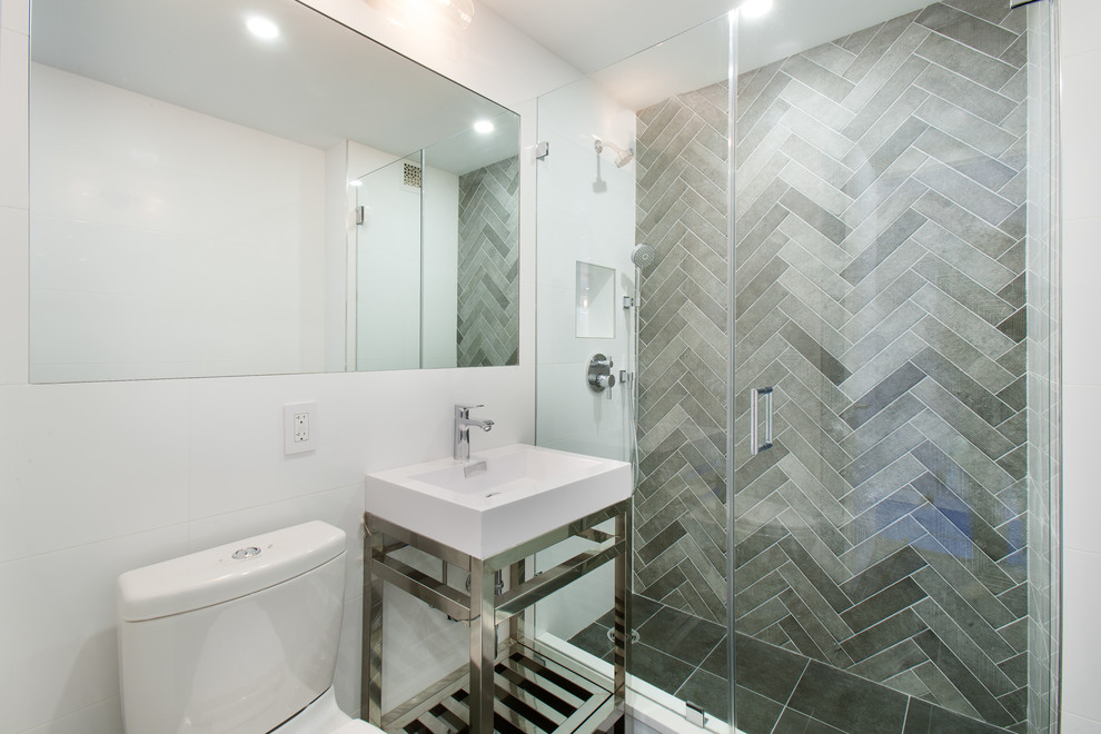Cette image montre une petite salle de bain design avec un placard sans porte, WC à poser, un carrelage gris, des carreaux de porcelaine, un mur blanc et un lavabo de ferme.