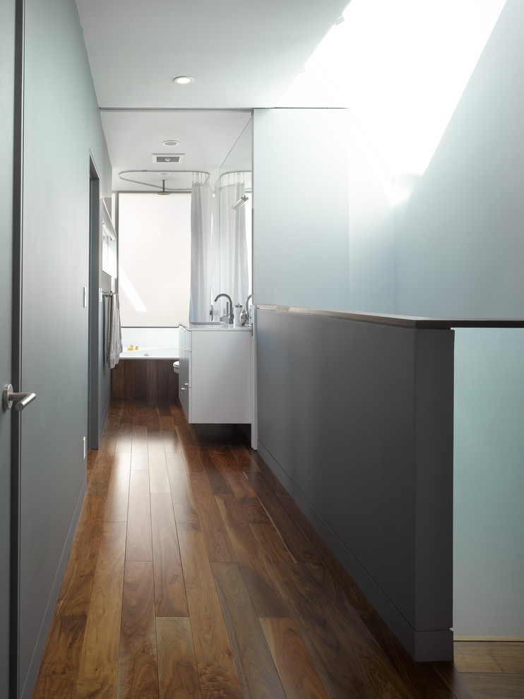 Ejemplo de cuarto de baño de nogal minimalista con sanitario de pared