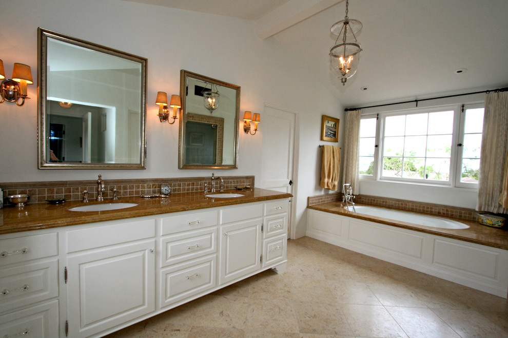 Пример оригинального дизайна: главная ванная комната в средиземноморском стиле с врезной раковиной, фасадами с выступающей филенкой, белыми фасадами, мраморной столешницей, полновстраиваемой ванной, раздельным унитазом, желтой плиткой, каменной плиткой, белыми стенами и полом из травертина