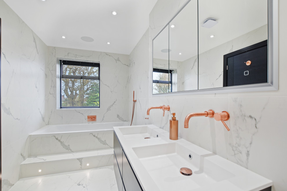 Example of a large trendy 3/4 gray tile and white tile gray floor and double-sink bathroom design in London with flat-panel cabinets, black cabinets, an integrated sink, white countertops and a floating vanity