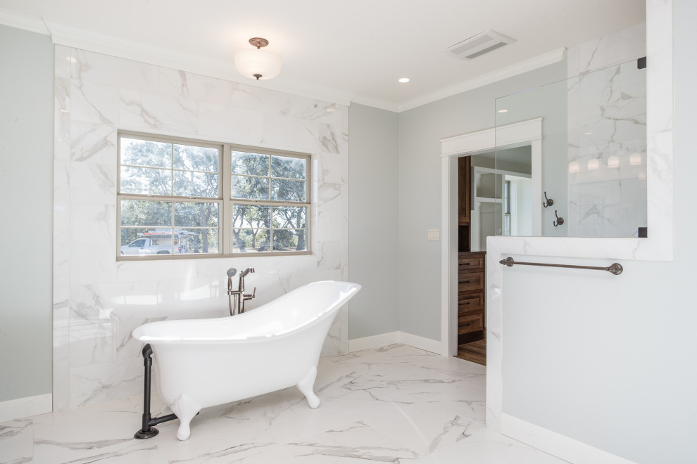 This is an example of a large country ensuite bathroom in Austin with shaker cabinets, brown cabinets, a claw-foot bath, a built-in shower, a one-piece toilet, white tiles, porcelain tiles, blue walls, porcelain flooring, a submerged sink, granite worktops, white floors, an open shower and brown worktops.