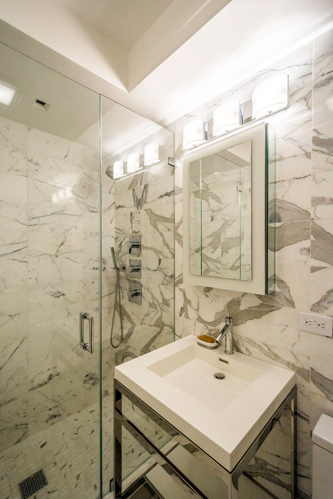 Example of a mid-sized trendy 3/4 gray tile, white tile and mosaic tile marble floor alcove shower design in New York with multicolored walls, an integrated sink and solid surface countertops