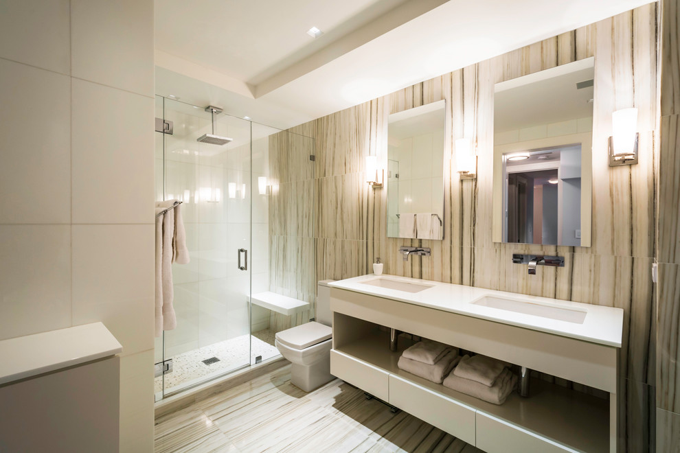 Design ideas for a large contemporary ensuite bathroom in New York with an alcove shower, a two-piece toilet, beige walls, marble flooring, an integrated sink, a freestanding bath, white tiles, ceramic tiles, flat-panel cabinets, white cabinets and solid surface worktops.