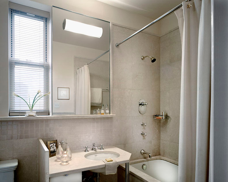 Exempel på ett mellanstort klassiskt en-suite badrum, med släta luckor, vita skåp, ett undermonterat badkar, en dusch/badkar-kombination, en toalettstol med hel cisternkåpa, beige kakel, stenkakel, beige väggar, kalkstensgolv, ett undermonterad handfat och bänkskiva i kalksten