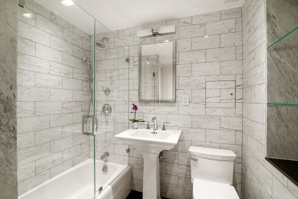 Diseño de cuarto de baño tradicional pequeño con bañera empotrada, ducha empotrada, sanitario de una pieza, baldosas y/o azulejos grises, baldosas y/o azulejos de piedra, paredes grises, aseo y ducha y lavabo con pedestal