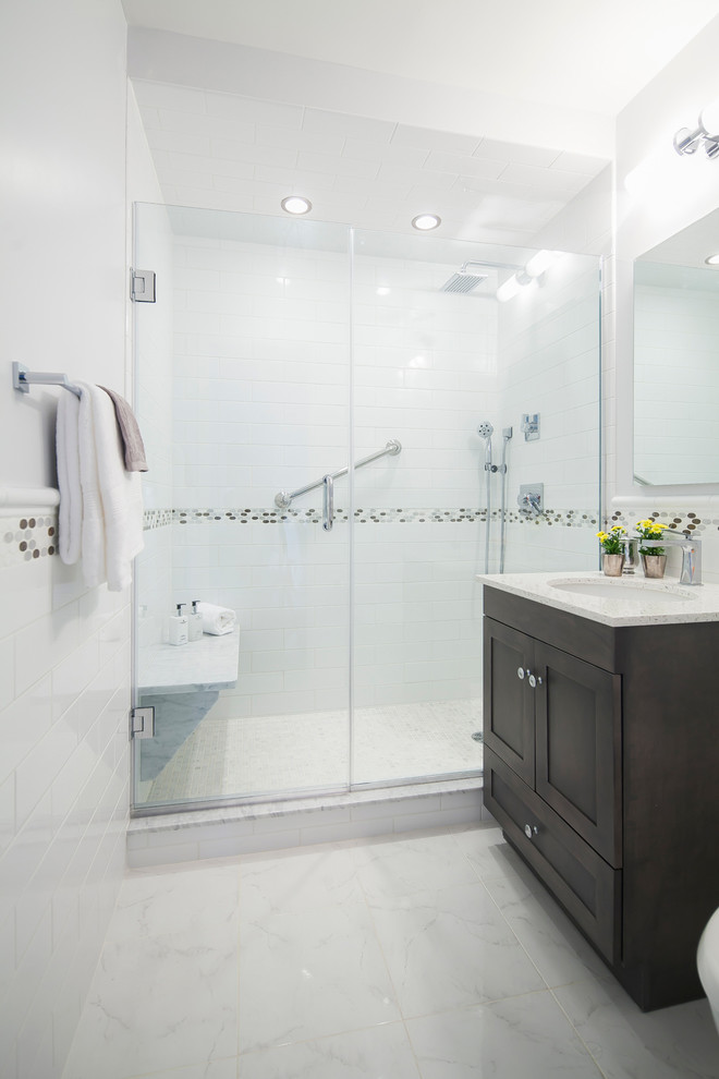 Inspiration for a modern bathroom in New York with a built-in sink, beaded cabinets, dark wood cabinets, engineered stone worktops, an alcove shower, white tiles, metro tiles, white walls and marble flooring.