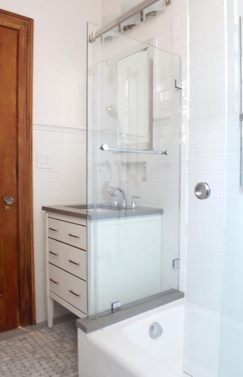Corner shower - small transitional 3/4 white tile and subway tile marble floor corner shower idea in New York with an undermount sink, flat-panel cabinets, white cabinets, soapstone countertops and white walls
