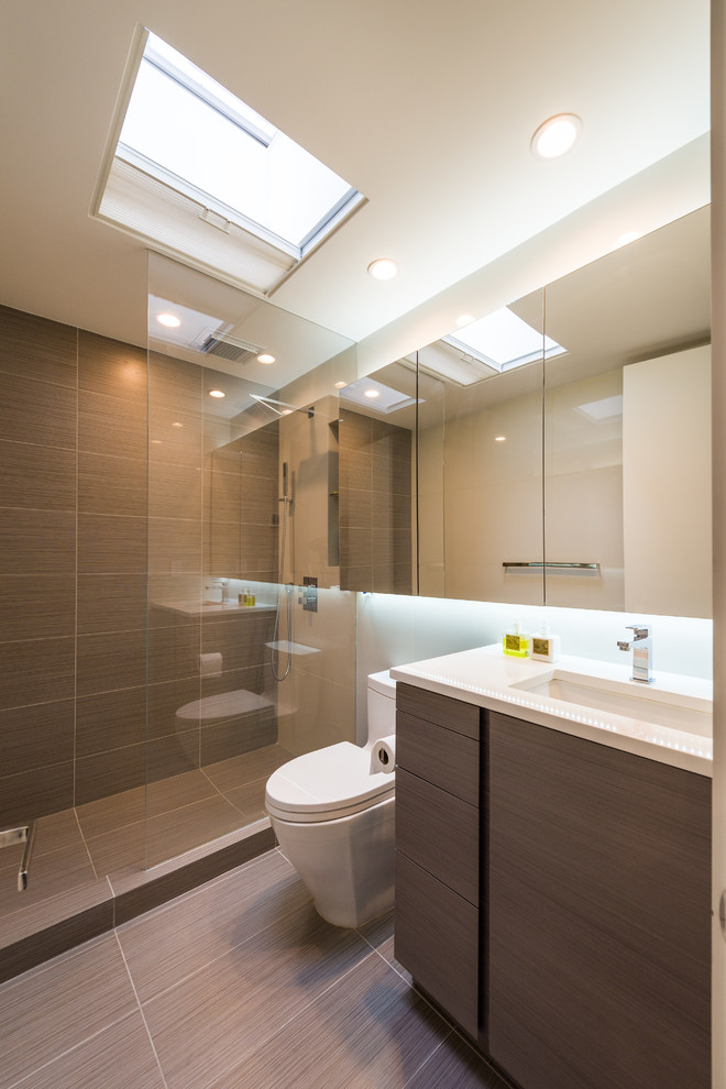 Aménagement d'une salle de bain classique en bois brun avec un lavabo encastré, un placard à porte plane, un plan de toilette en marbre, une douche ouverte et WC à poser.