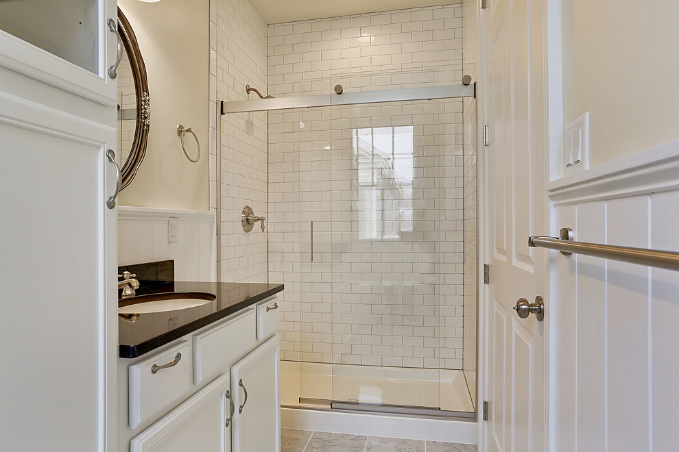Idées déco pour une douche en alcôve classique de taille moyenne avec un lavabo encastré, un placard avec porte à panneau encastré, des portes de placard blanches, un plan de toilette en granite, un carrelage blanc, un carrelage métro, un mur beige et un sol en marbre.