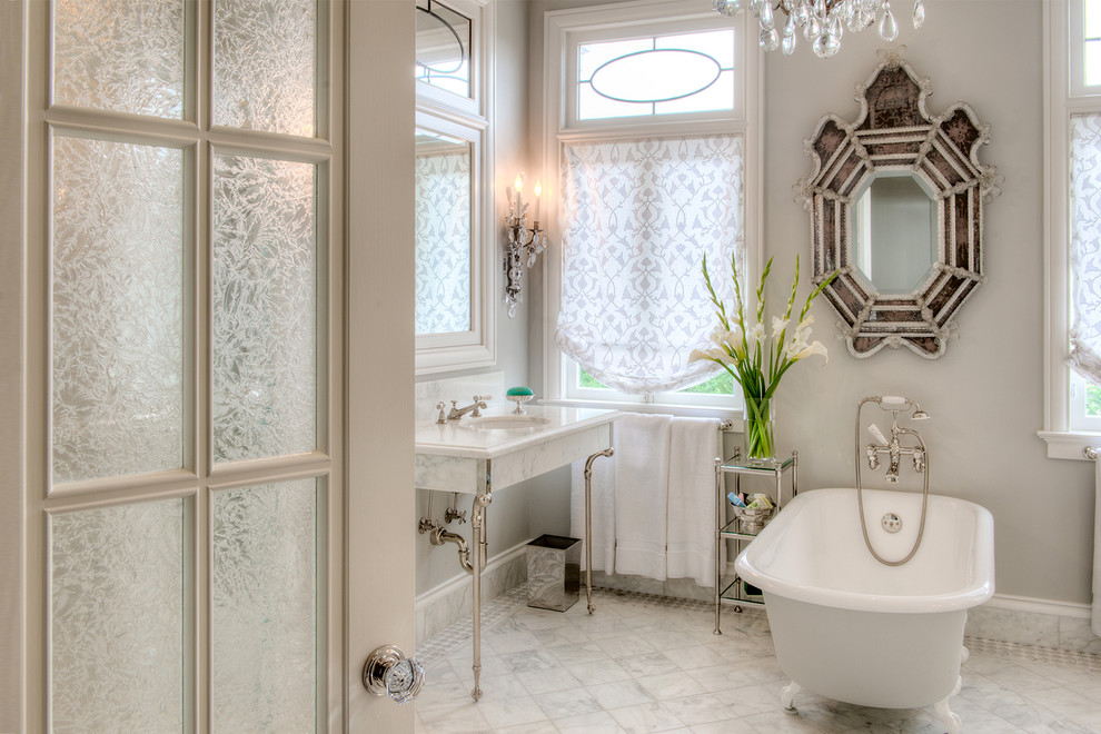 На фото: ванная комната в классическом стиле с консольной раковиной, ванной на ножках и белой плиткой