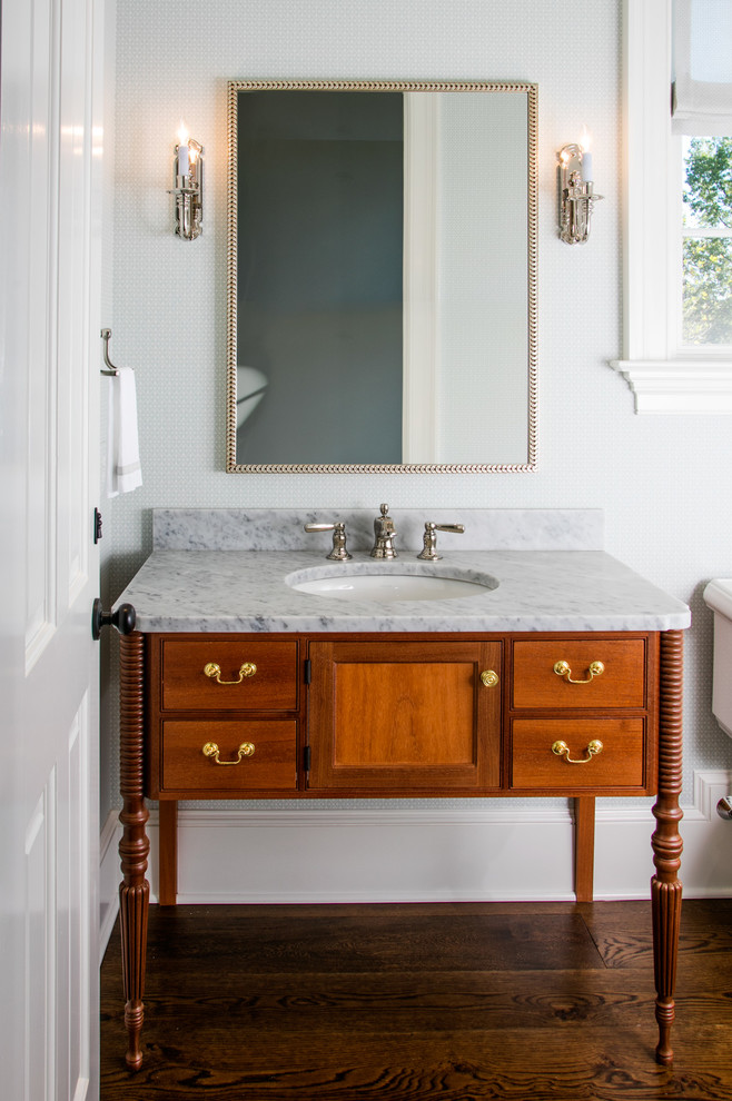 Klassisches Badezimmer mit hellbraunen Holzschränken, weißer Wandfarbe, dunklem Holzboden, Unterbauwaschbecken und Kassettenfronten in Philadelphia