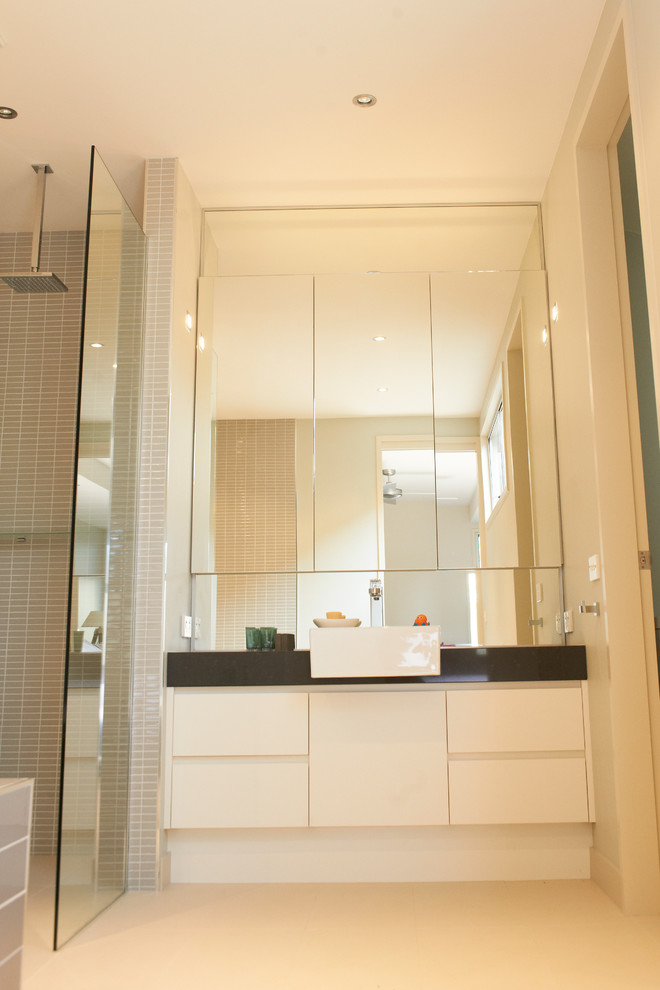 Свежая идея для дизайна: главная ванная комната среднего размера в современном стиле с раковиной с несколькими смесителями, плоскими фасадами, белыми фасадами, столешницей из гранита, накладной ванной, угловым душем, инсталляцией, серой плиткой, керамической плиткой, белыми стенами и полом из керамической плитки - отличное фото интерьера