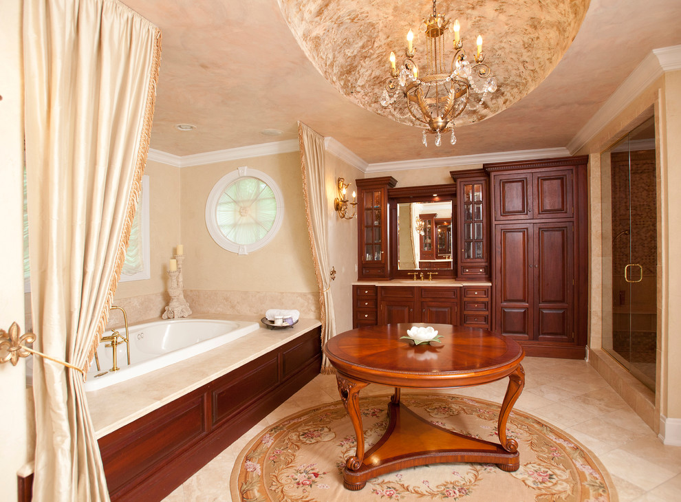 Exemple d'une salle de bain chic en bois foncé avec un placard avec porte à panneau surélevé et une baignoire posée.