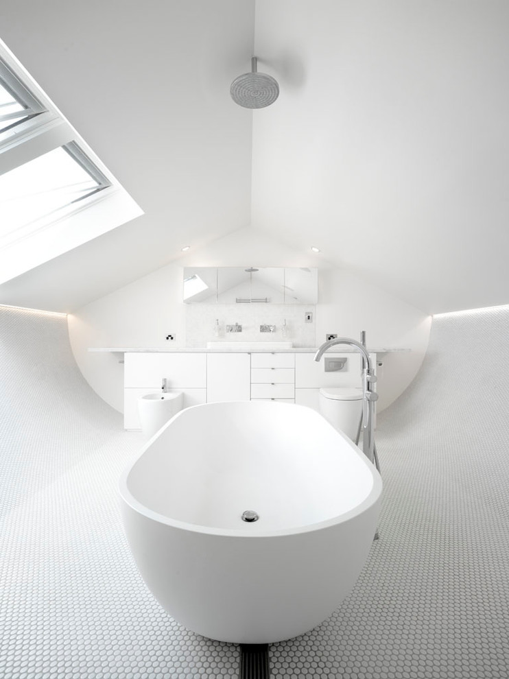 Ejemplo de cuarto de baño contemporáneo de tamaño medio con armarios con paneles lisos, puertas de armario blancas, bañera exenta, baldosas y/o azulejos blancos, paredes blancas y suelo con mosaicos de baldosas