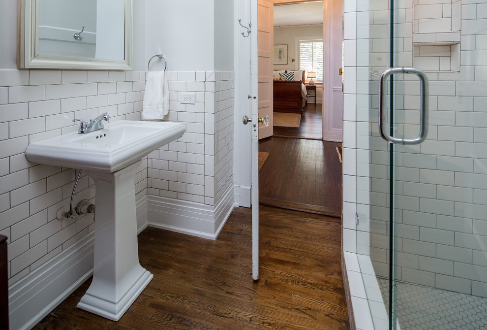 Diseño de cuarto de baño tradicional pequeño con ducha esquinera, paredes blancas, suelo de madera oscura, aseo y ducha y lavabo con pedestal