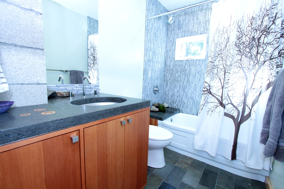 Example of a small transitional gray tile and mosaic tile ceramic tile bathroom design in Seattle with flat-panel cabinets, medium tone wood cabinets, a two-piece toilet, green walls, an undermount sink, concrete countertops and gray countertops