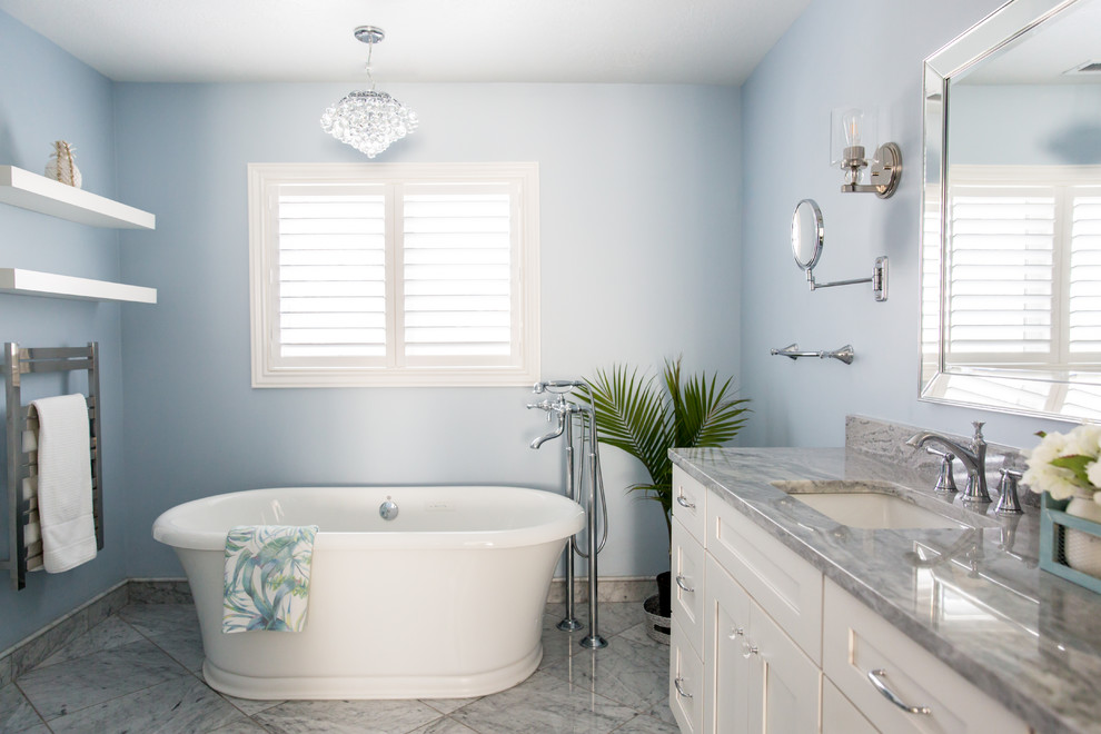 Inspiration for a large nautical ensuite bathroom in Salt Lake City with shaker cabinets, white cabinets, a freestanding bath, grey tiles, blue walls, marble flooring, a submerged sink, engineered stone worktops, grey floors and grey worktops.