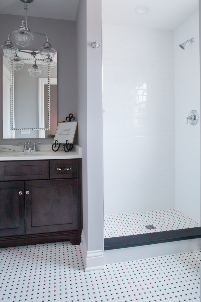 Inredning av ett lantligt mellanstort badrum, med vita skåp, en dusch i en alkov, grå kakel, grå väggar, ett undermonterad handfat och granitbänkskiva