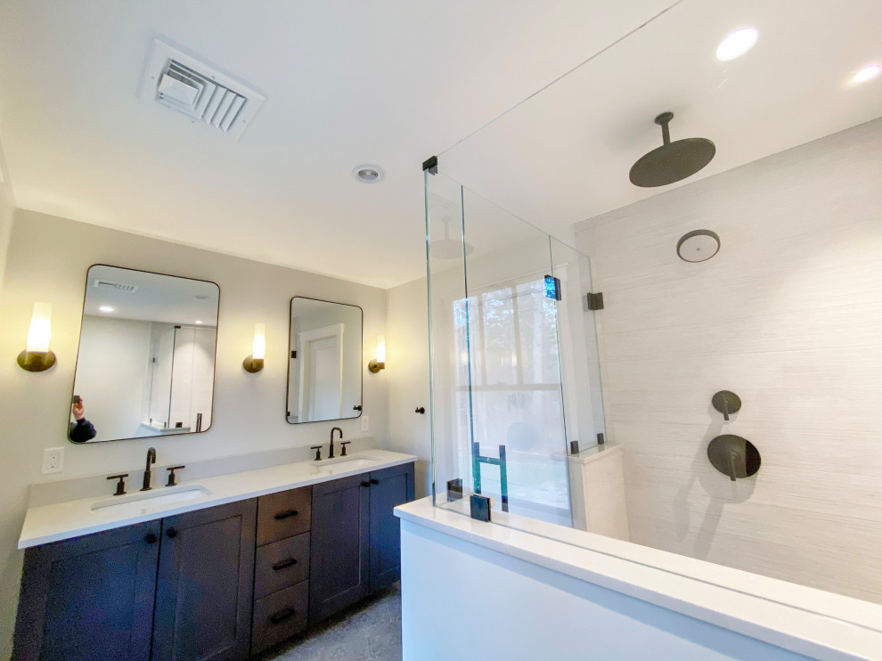 Cette image montre une grande salle de bain principale design avec un placard à porte shaker, des portes de placard noires, une douche d'angle, WC séparés, un mur blanc, carreaux de ciment au sol, un lavabo encastré, un plan de toilette en quartz, un sol gris, une cabine de douche à porte battante et un plan de toilette blanc.