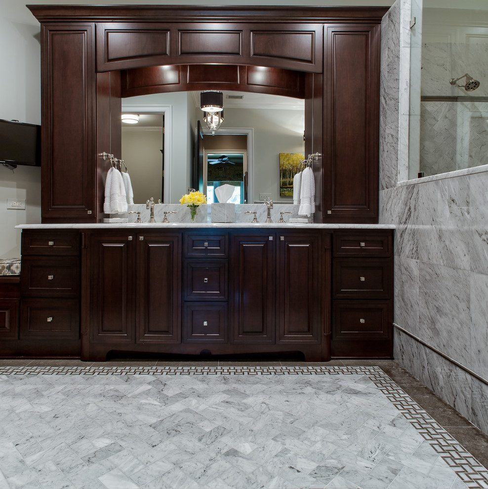 Inspiration for a mid-sized timeless master gray tile and stone tile limestone floor bathroom remodel in Charlotte with an undermount sink, recessed-panel cabinets, dark wood cabinets, marble countertops, a two-piece toilet and gray walls