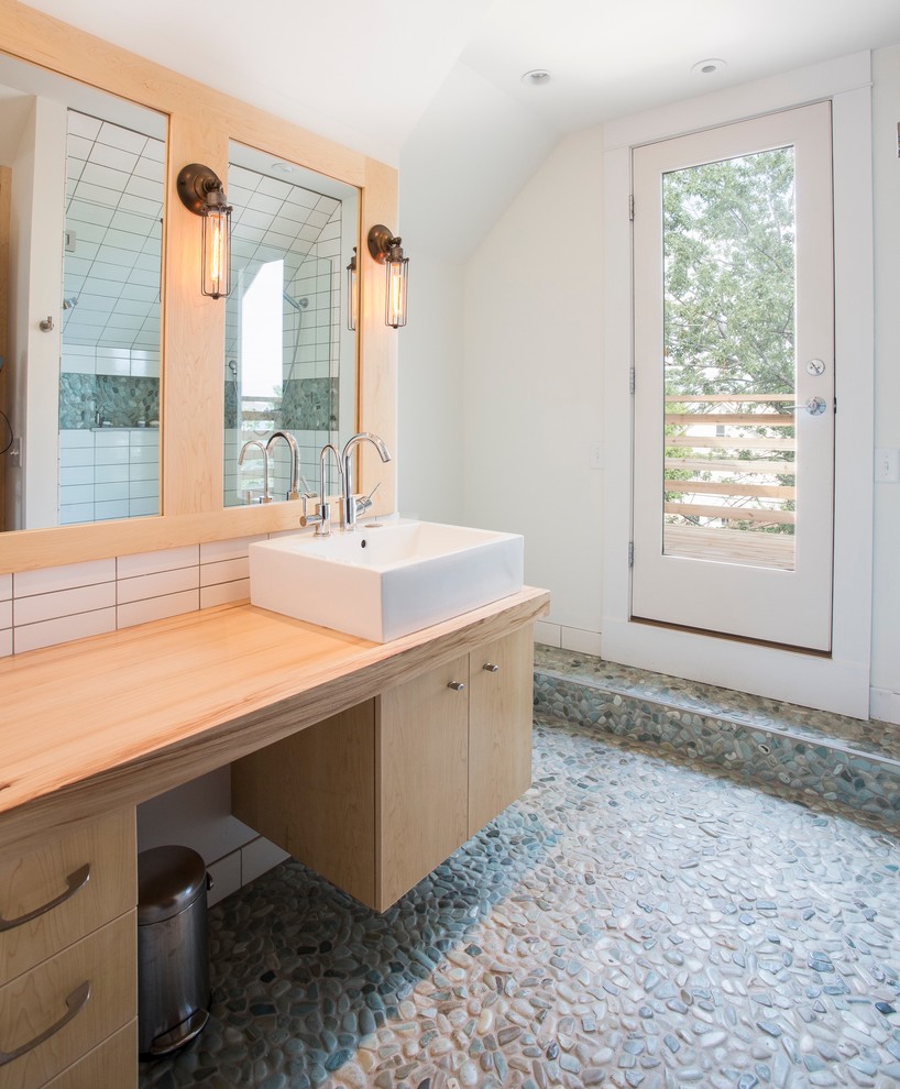 Свежая идея для дизайна: ванная комната среднего размера в современном стиле с настольной раковиной, плоскими фасадами, светлыми деревянными фасадами, душем в нише, белой плиткой, керамической плиткой, белыми стенами, полом из галечной плитки и столешницей из дерева - отличное фото интерьера