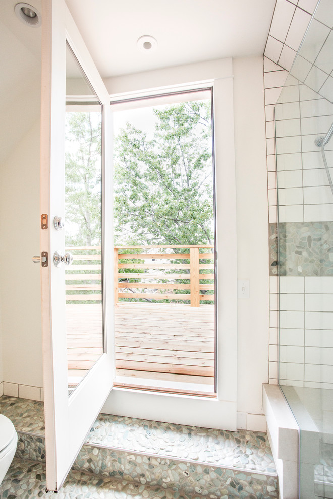 На фото: большая ванная комната в современном стиле с плоскими фасадами, светлыми деревянными фасадами, душем в нише, белой плиткой, плиткой кабанчик, белыми стенами, полом из галечной плитки, душевой кабиной, столешницей из дерева и душем с распашными дверями
