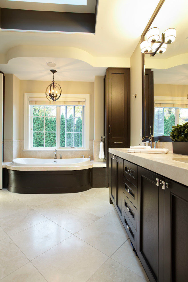 Inspiration for a large transitional master white tile porcelain tile drop-in bathtub remodel in Toronto with shaker cabinets, dark wood cabinets and beige walls