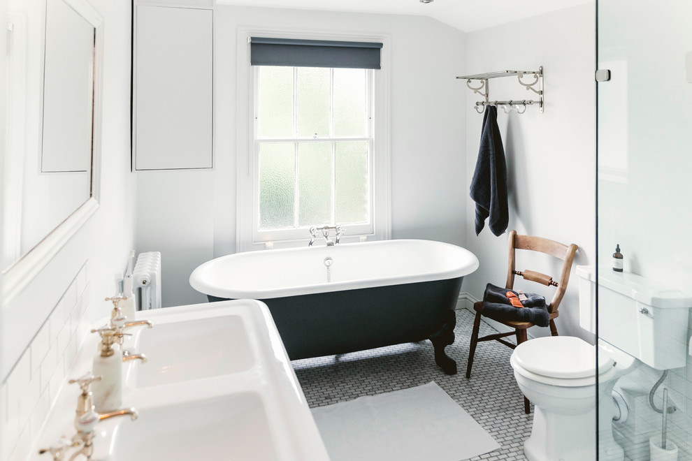 Идея дизайна: ванная комната в стиле кантри с ванной на ножках, раздельным унитазом, белой плиткой, плиткой кабанчик, белыми стенами, полом из мозаичной плитки, подвесной раковиной и серым полом