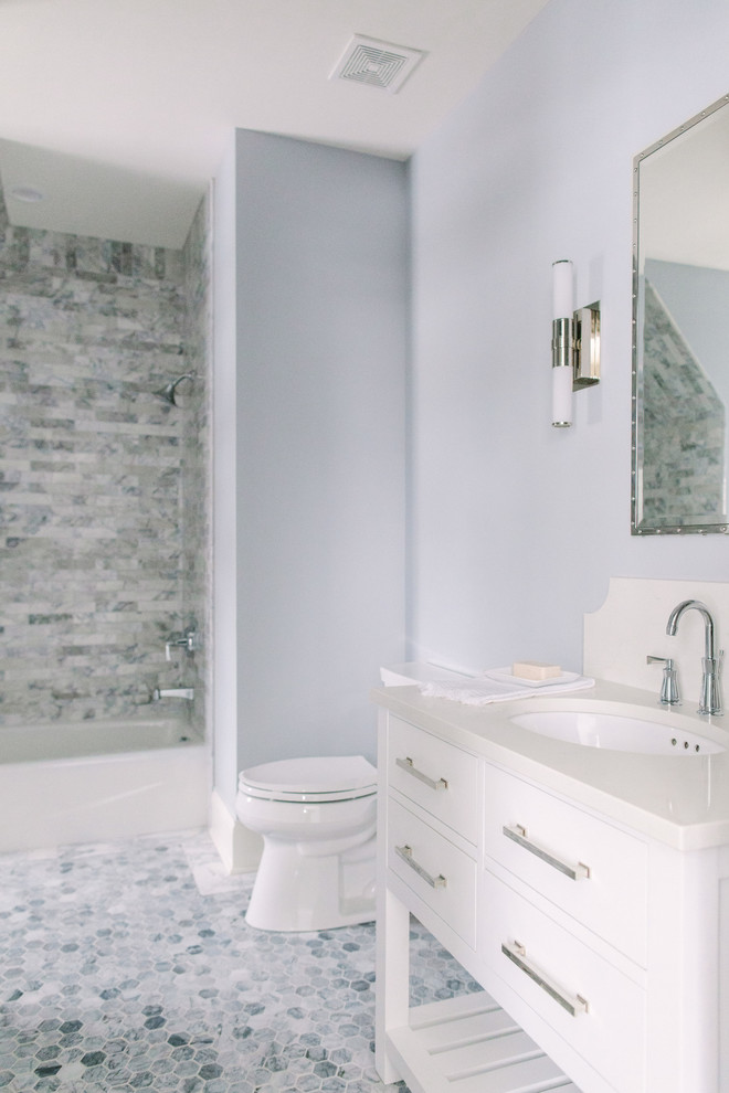 Inredning av ett klassiskt en-suite badrum, med skåp i shakerstil, vita skåp, ett badkar i en alkov, en dusch/badkar-kombination, grå väggar, marmorgolv och ett undermonterad handfat